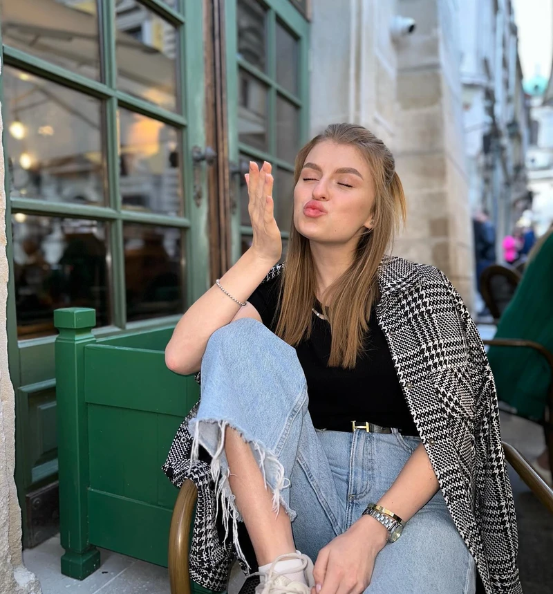 Katya outside a café in a checked jacket